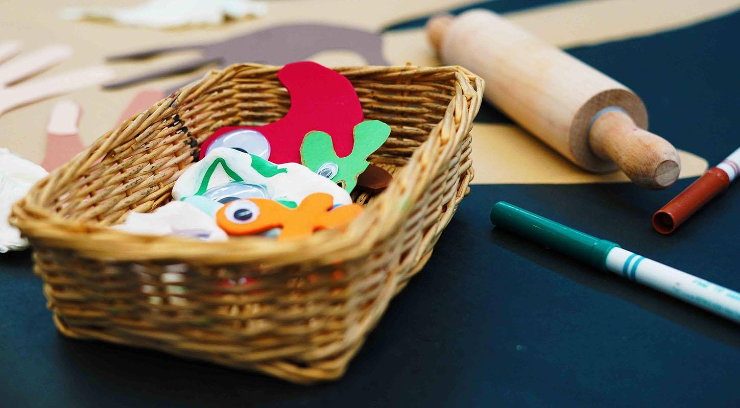 A small basket containing craft 'germs' made up paper, clay, and googly eyes