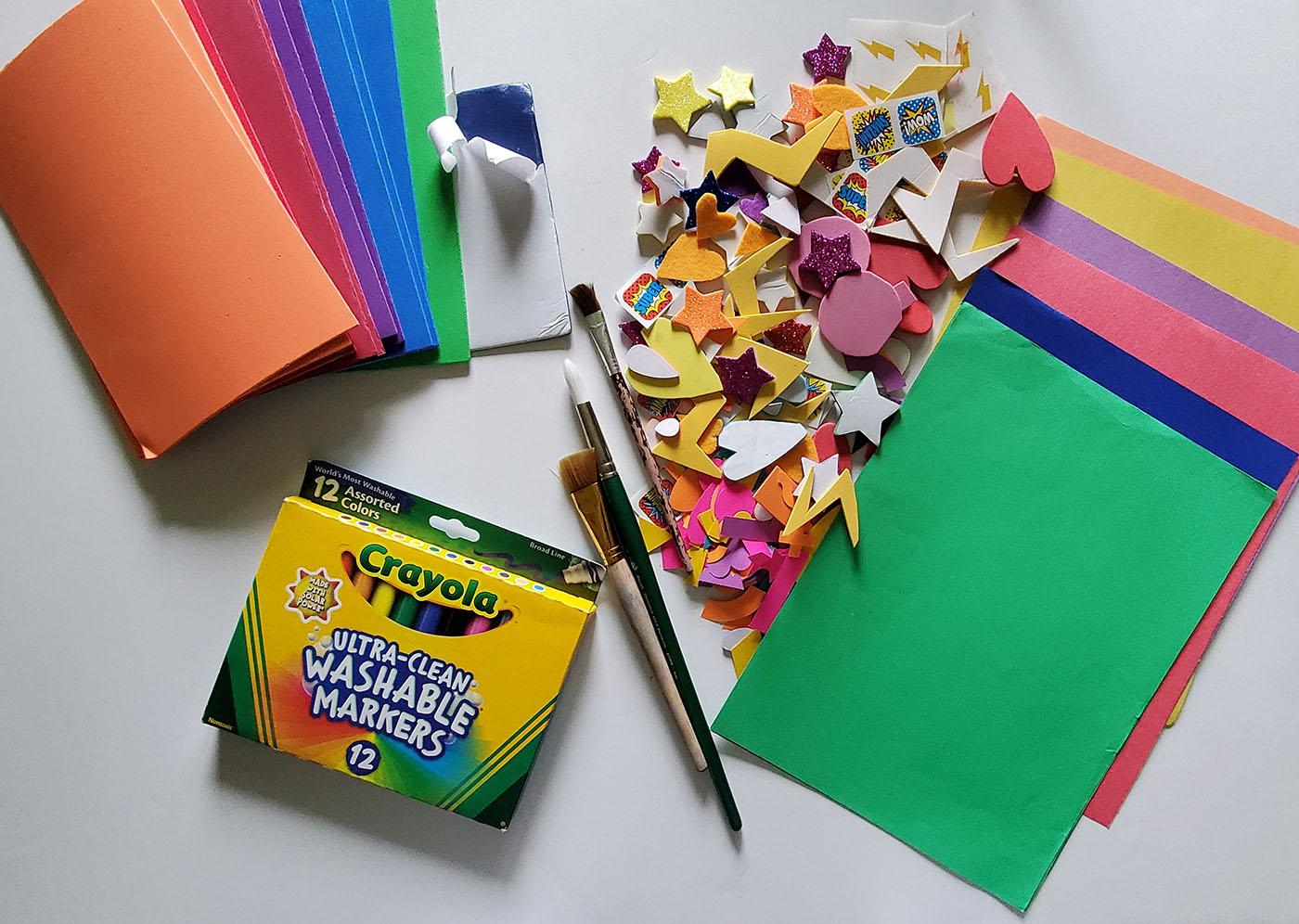 Craft items including crayons, paper, and shapes on a table