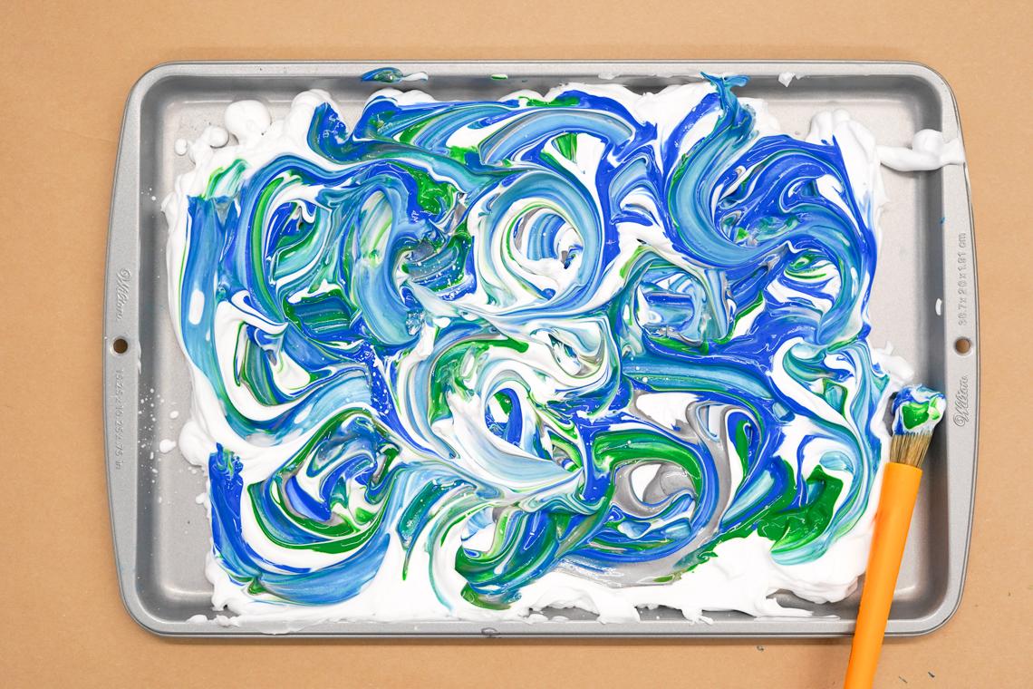 Photo of a sheet pan with shaving cream and painting swirled together on top of it