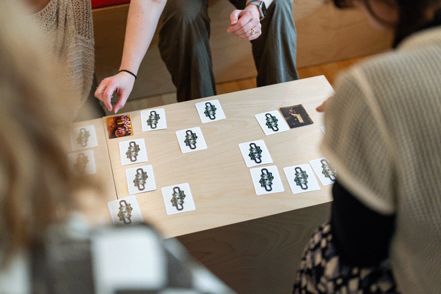 A series of images of people playing a card game with prints of old paintings
