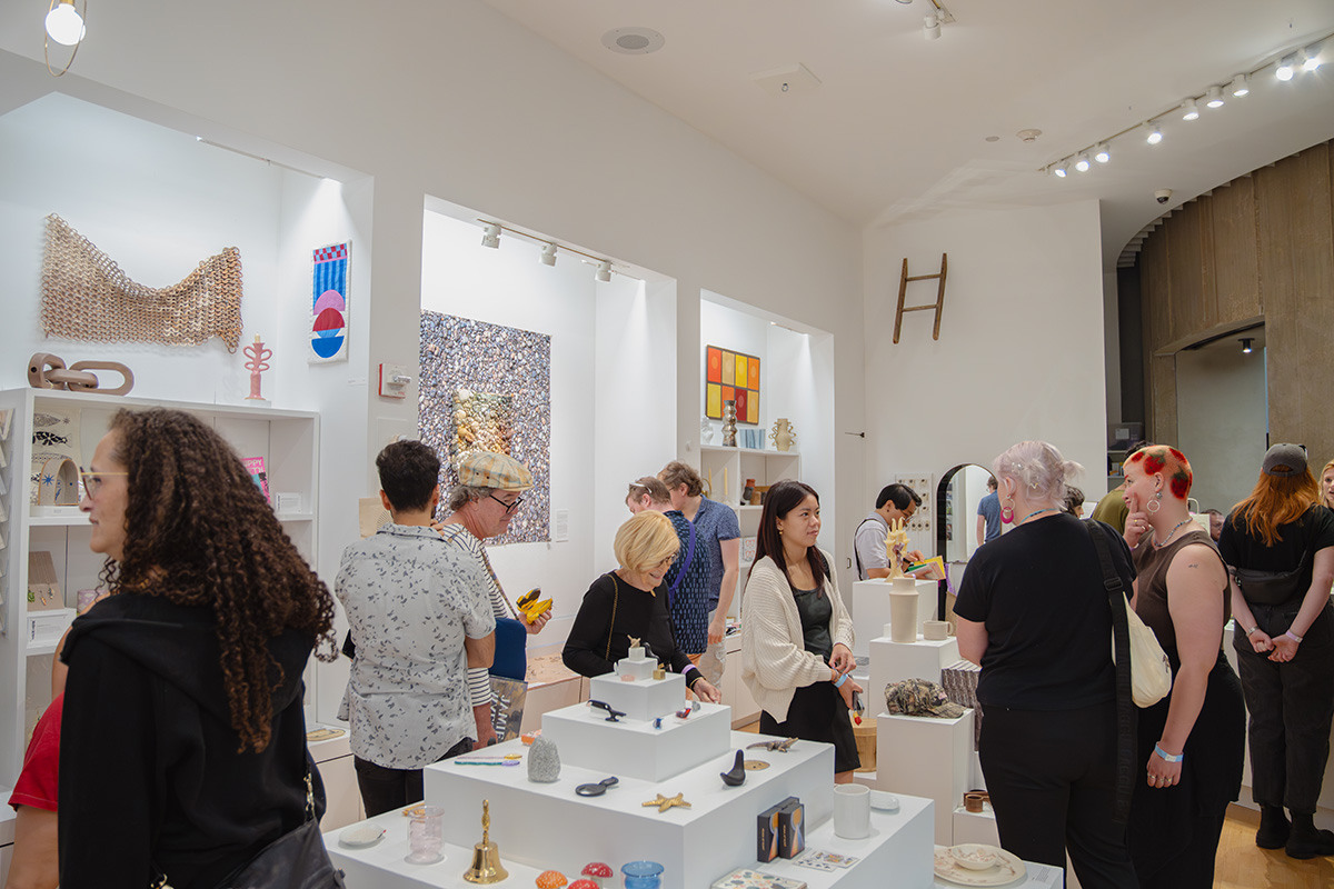 People shopping in a bright, well stocked museum store