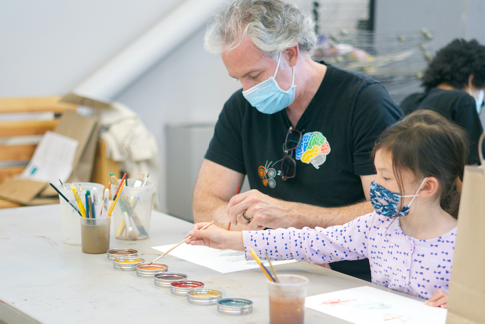 Child and parent participating in Community Day art activity 