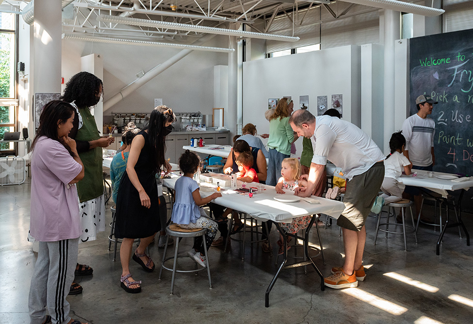 Adults and children working on crafts in the Frye Art Studio