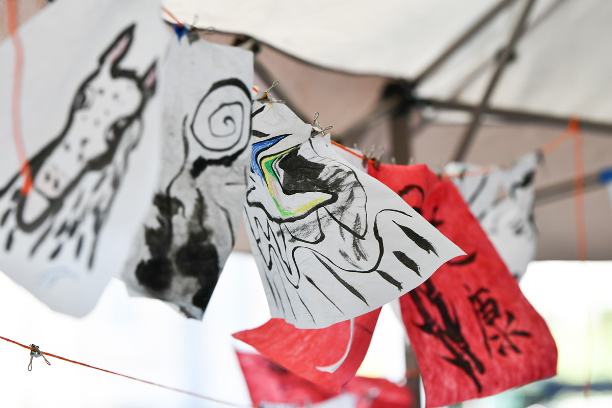 Sheets of paper with draping hanging from a line in a tent