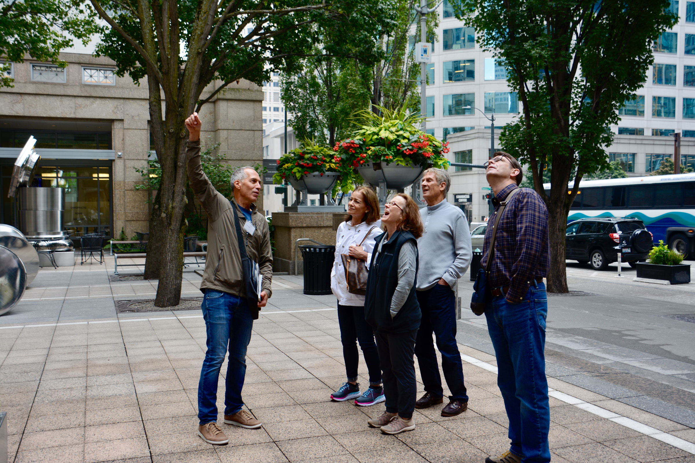 Photo of a group of people observing buildings on architecture tour outside
