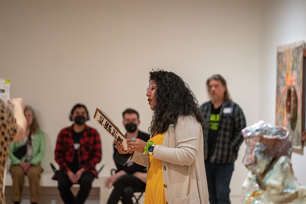 A person reading a poem to people in a gallery at the Frye Art Museum