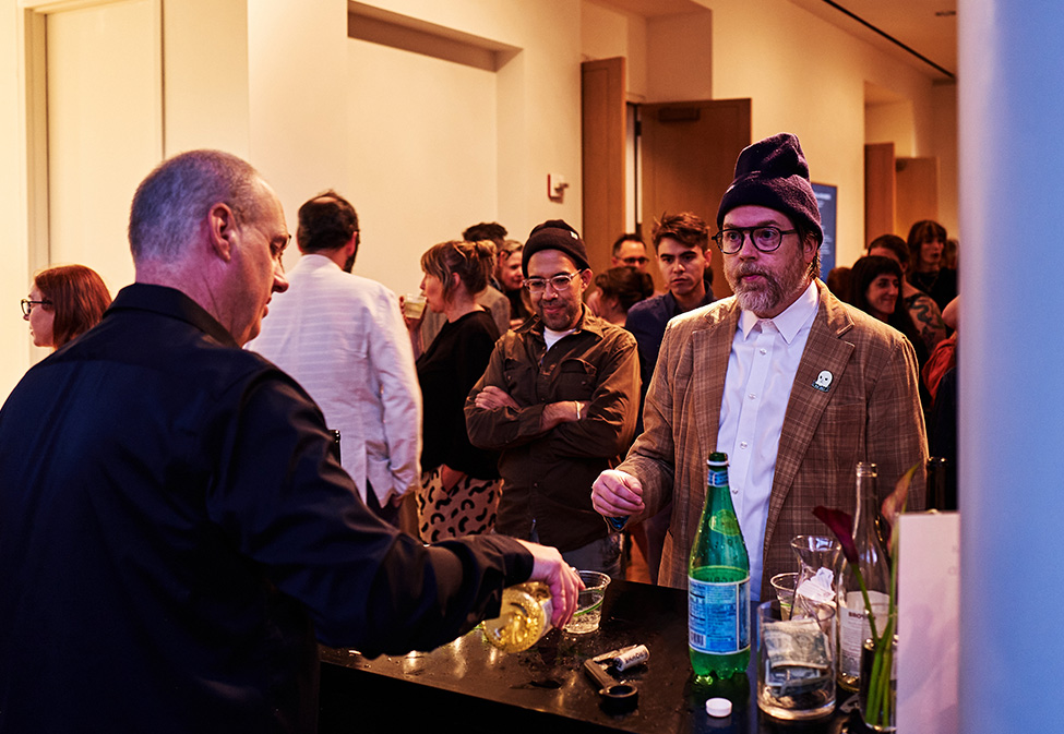 A person standing at a bar while a drink is being poured during an event at the Frye Art Museum