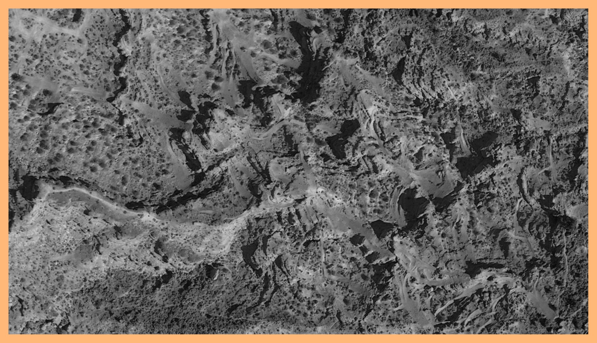Black and white photograph of a mountain surface taken in Virgin, Utah. The image is surrounded by an orange border.