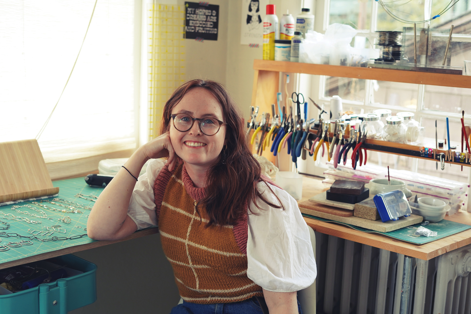 Photo of Devon Simpson sitting at a jewelry bench looking at the camera and smiling