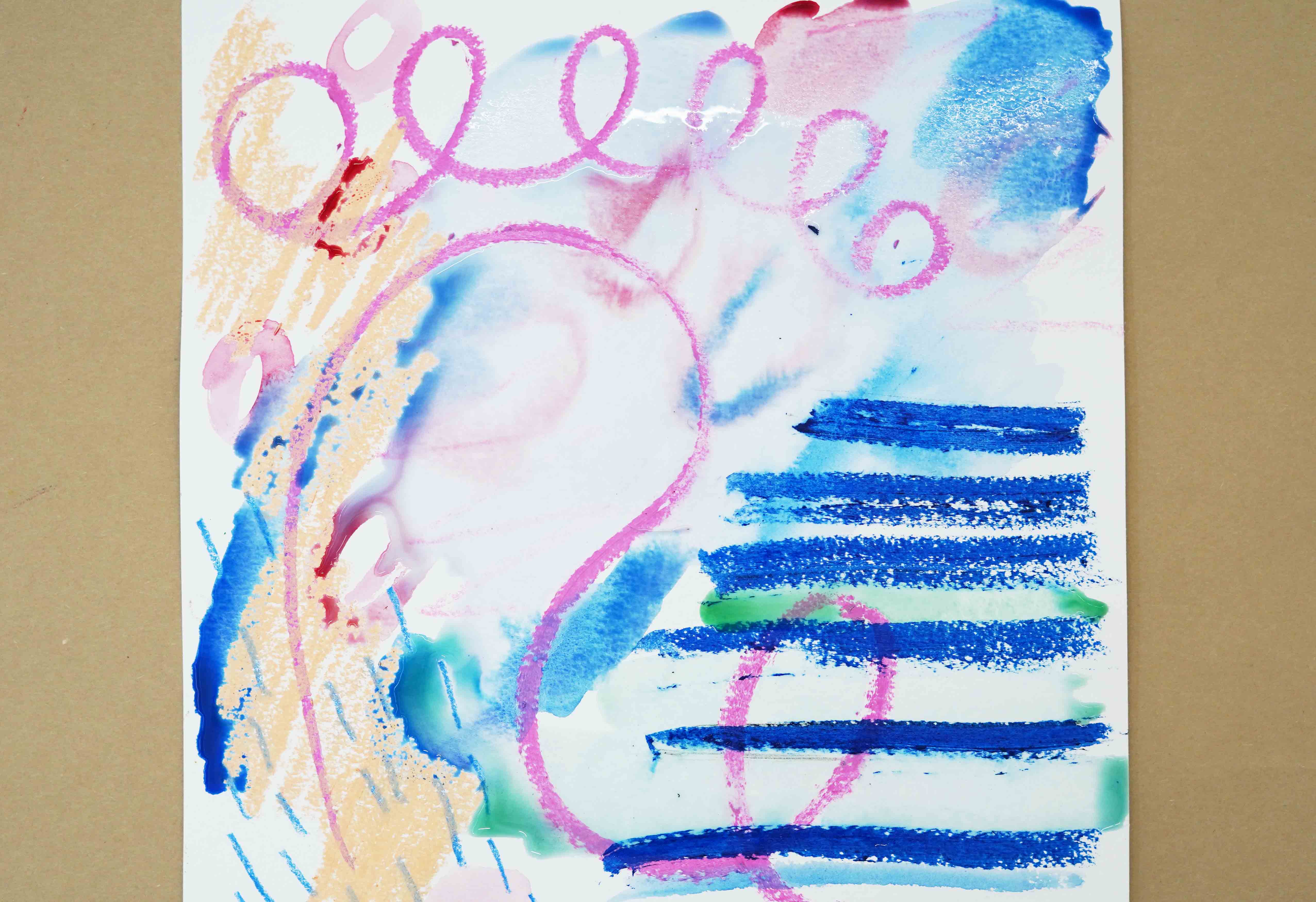 Photo of an abstract artwork with pink squiggles, blue stripes, and blue, green, and orange color fields laying on a surface