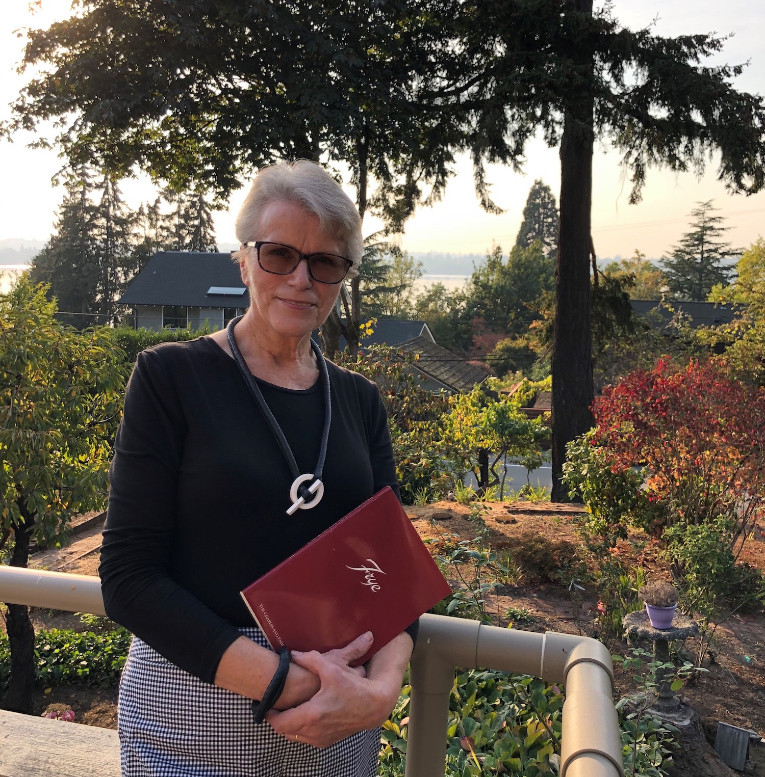 Photograph of Petra Heussner-Walker holding a red book with the word "Frye" visible on the cover