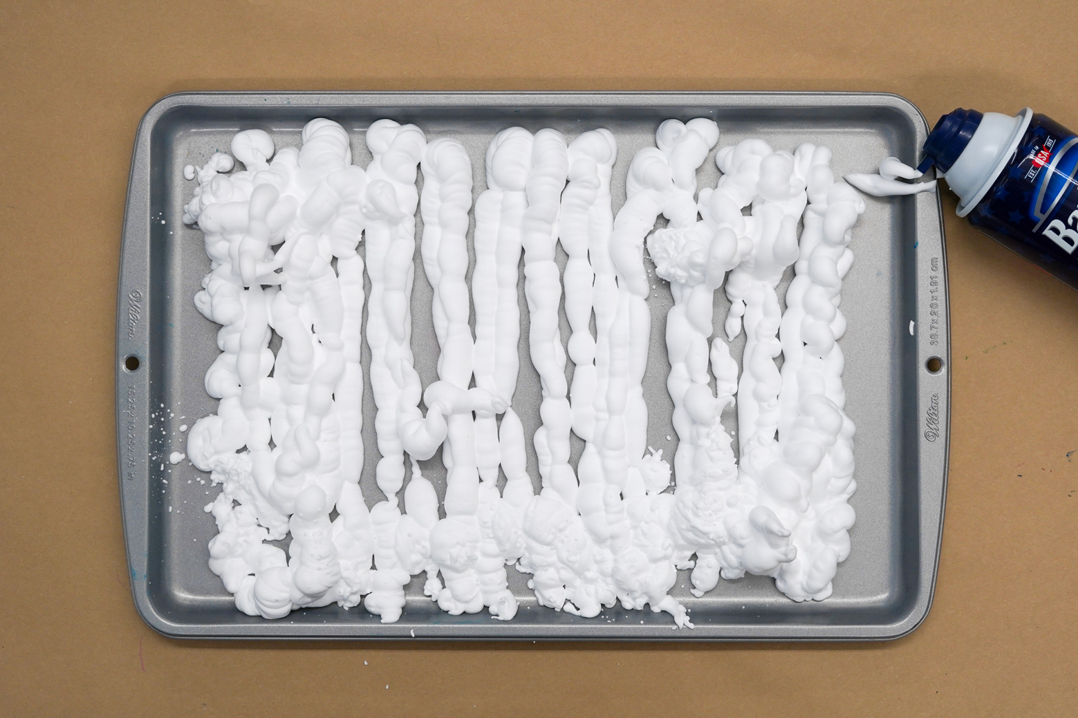 Photo of a baking sheet with shaving cream sprayed in rows over it