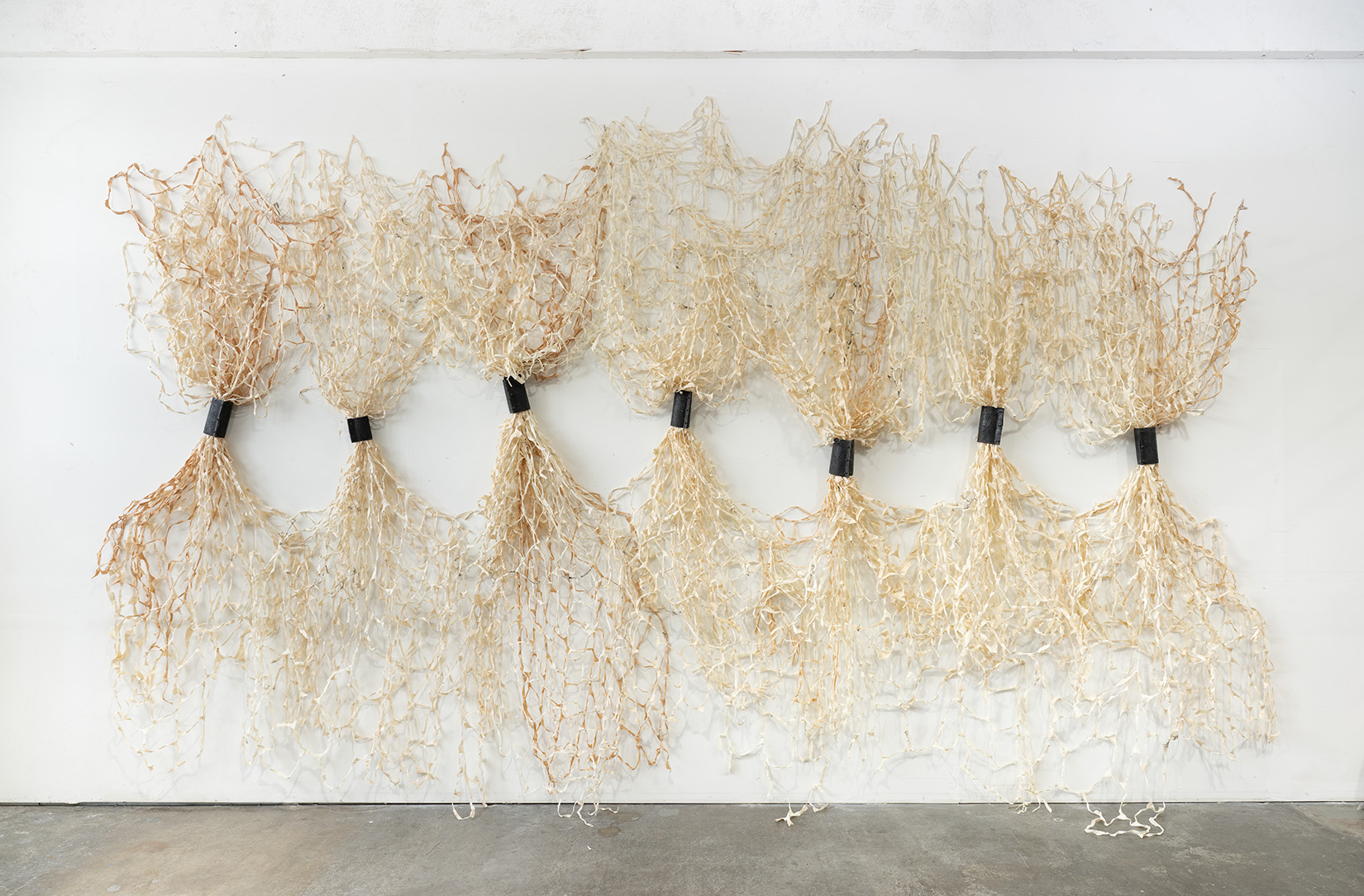 A large artwork consisting of bound, vertical sheaths of fabric