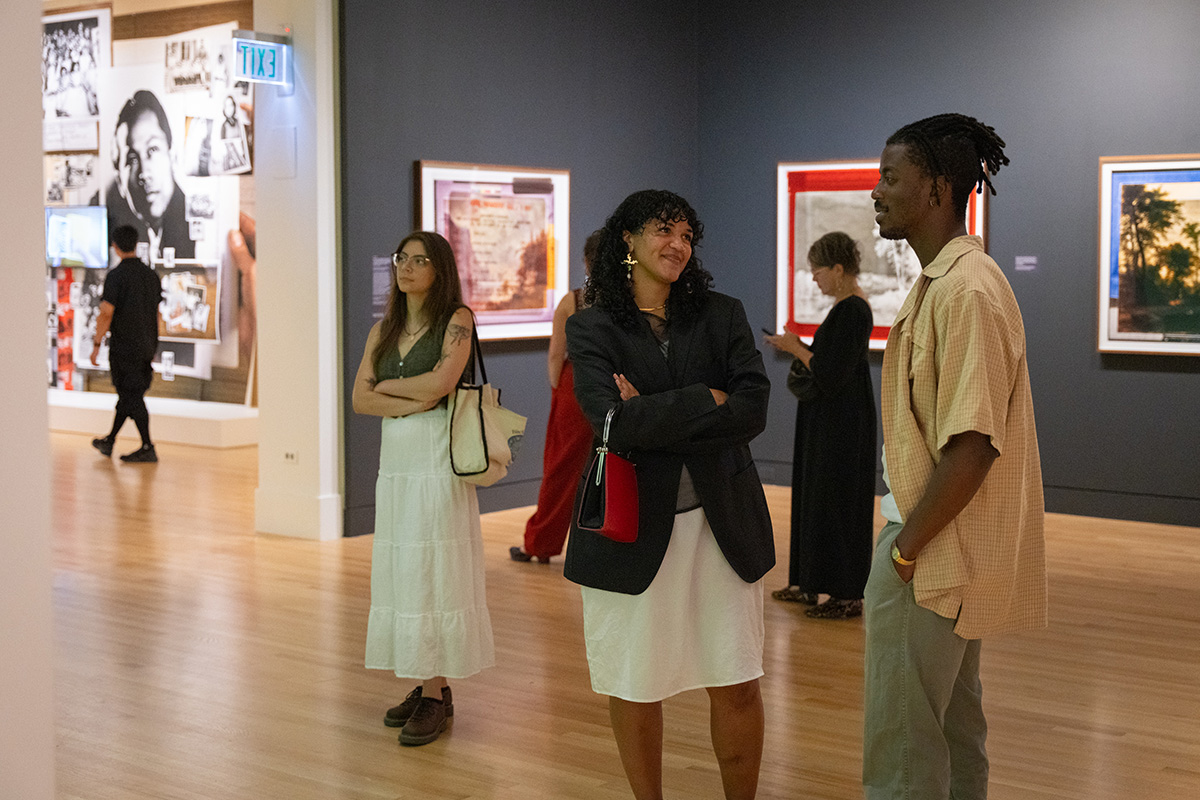 Young people smiling and chatting in a museum gallery space