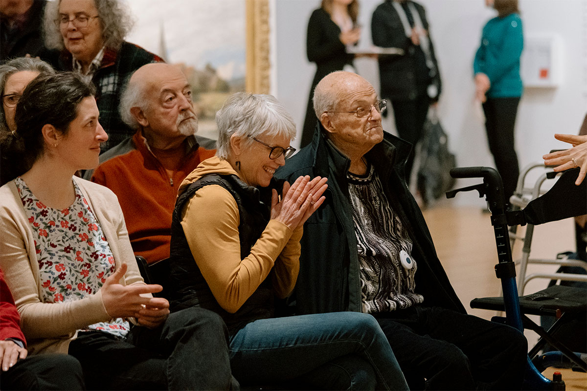Older adults sitting in temporary chairs and chatting and smiling