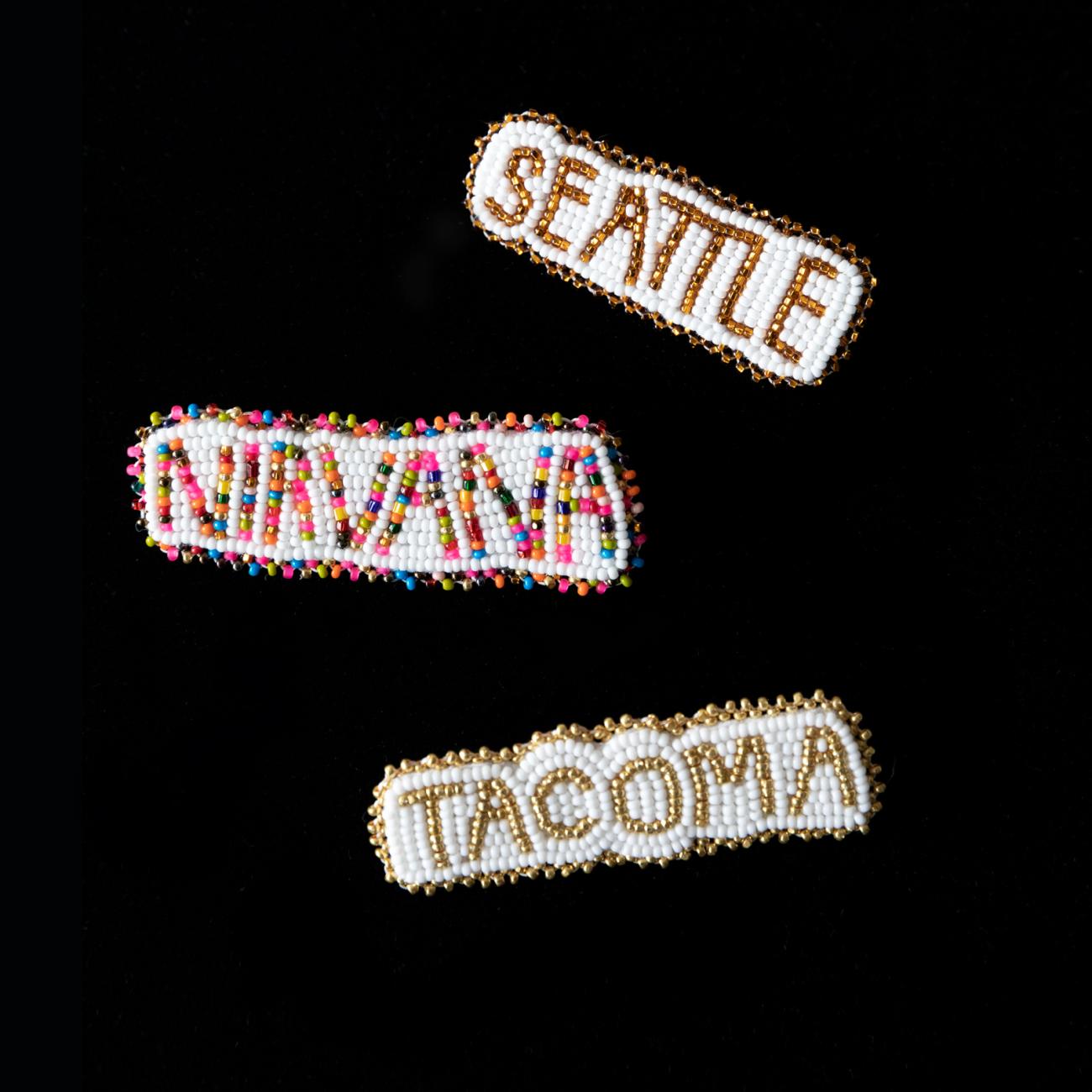 Photo of three beaded pieces with the words "Seattle" "Nirvana" and "Tacoma" by artist Naomi Parker