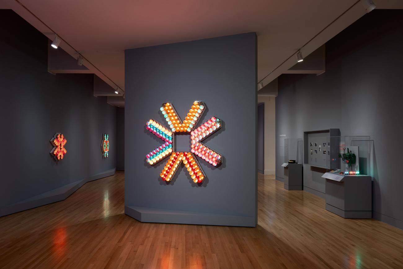 A gallery space with light artworks in geometric shapes