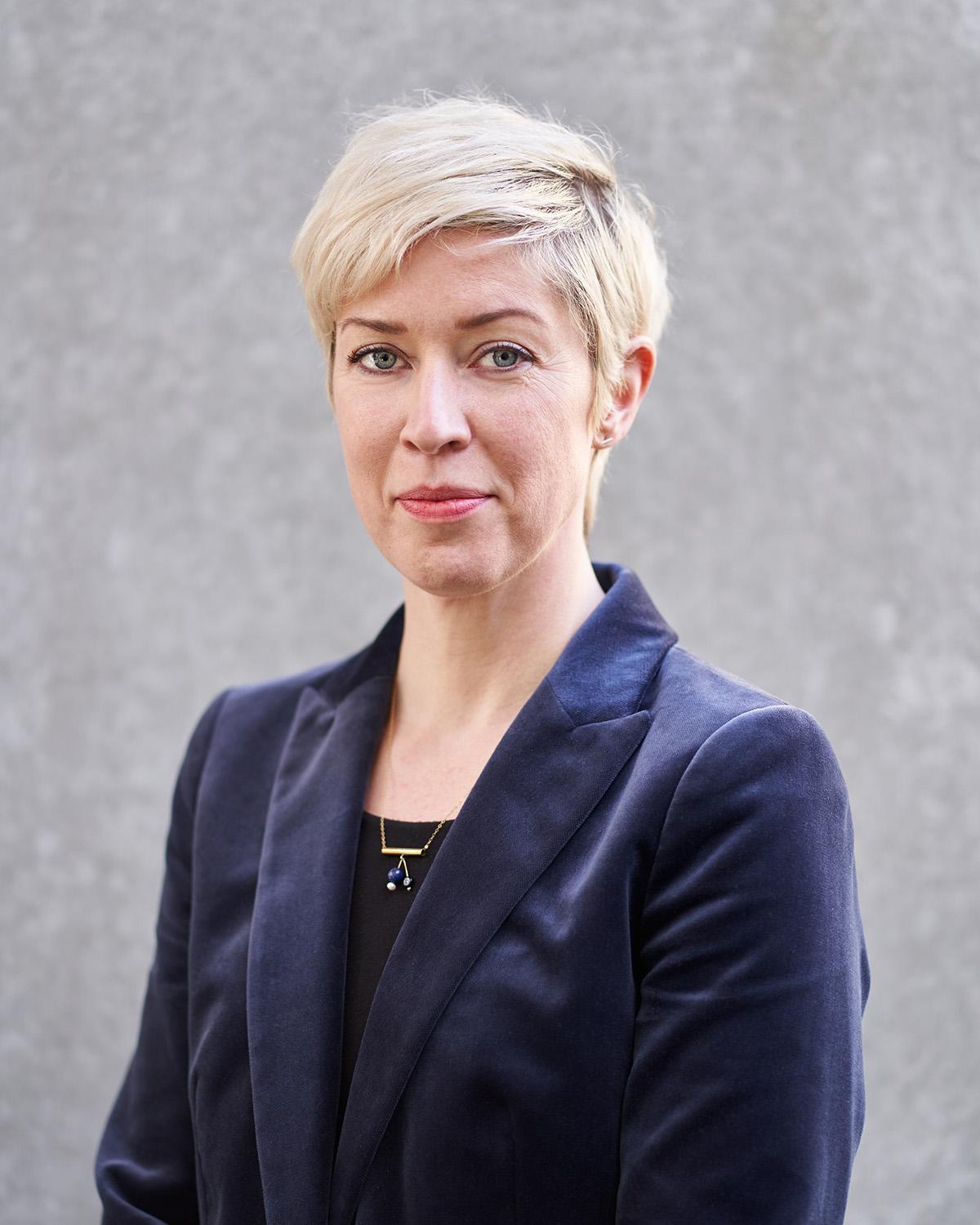 Professional headshot photograph of a woman with short blonde hair