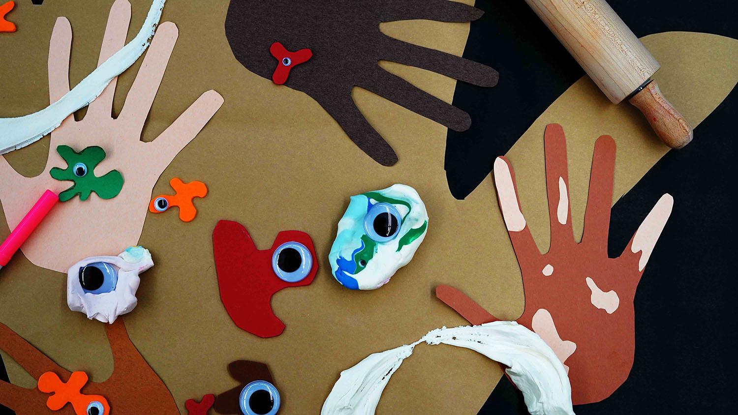 Construction paper hands and 'germs' made of clay, paper, and googly eyes