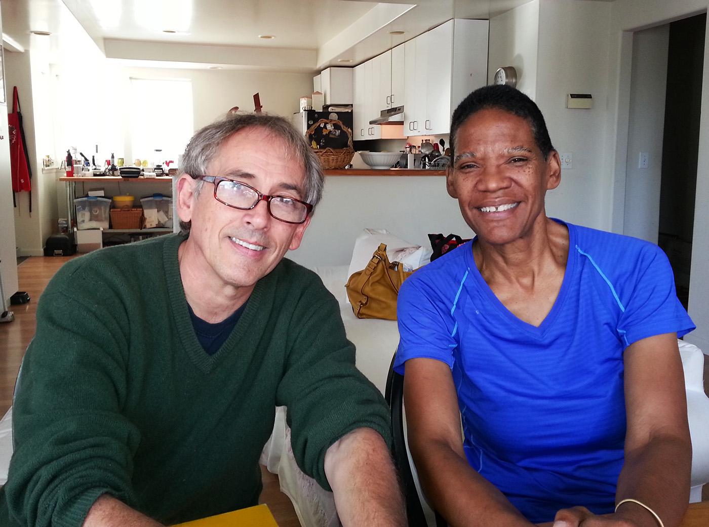 Two people sitting at a table and smiling at the camera