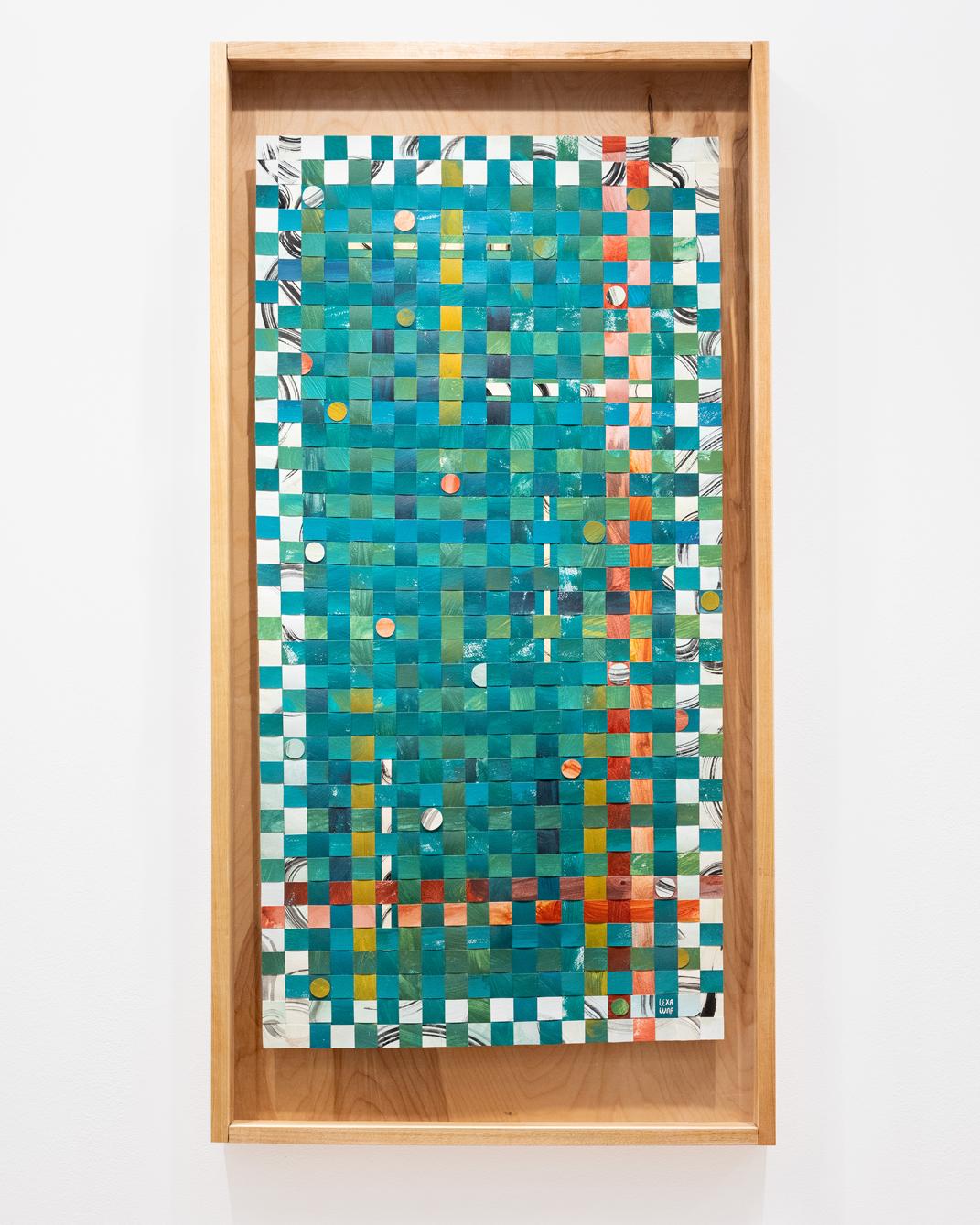 Photo of a rectangular woven paper artwork that's multiple colors including white, yellow, red, and primarily teal