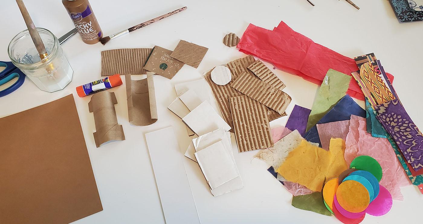 Crafting materials including cardboard, paper, and glue on a table