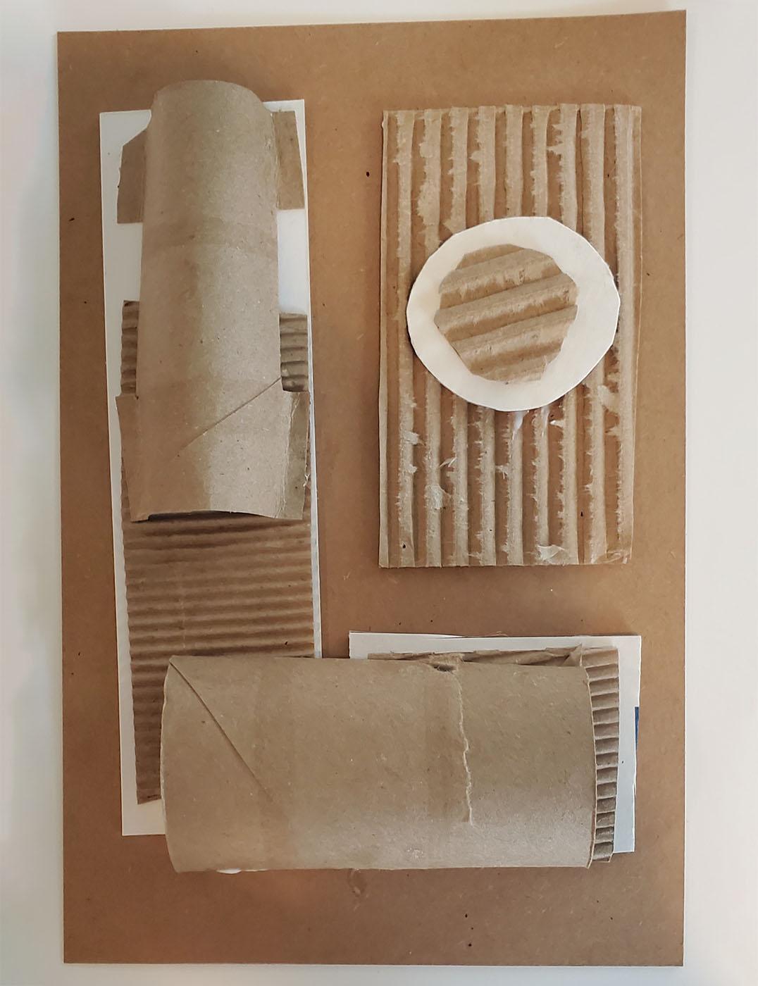 Pieces of cardboard in a variety of shapes stacked on top of a base sheet of cardboard