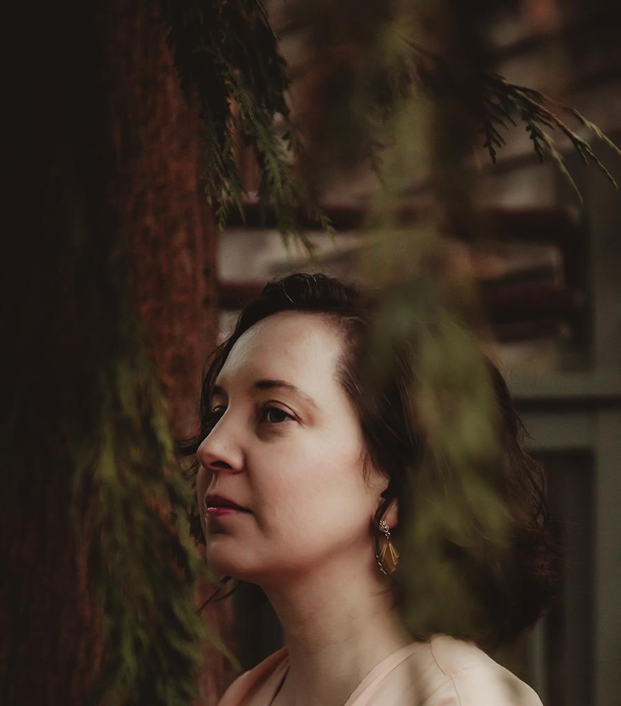 A dramatically lit photo of a woman in three quarters profile