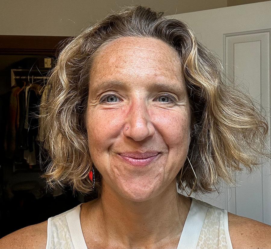 A close-up photo of a smiling woman with blonde hair