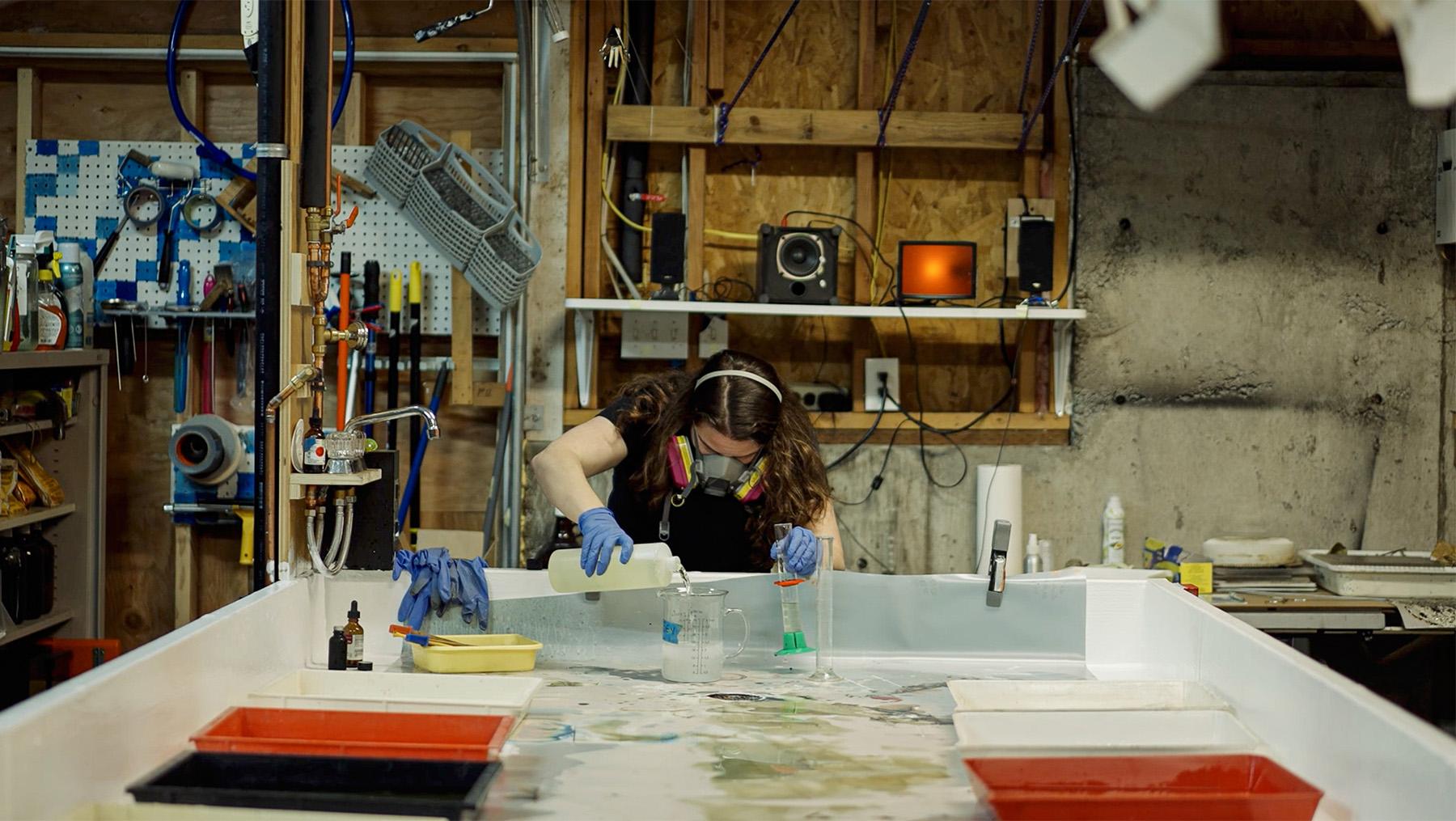 Rachel Wolf mixing chemicals in her darkroom