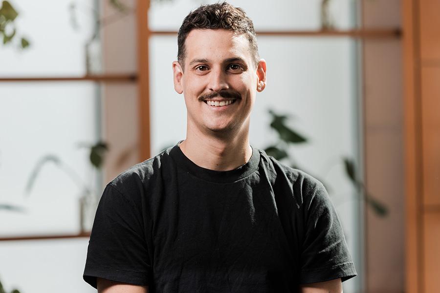 A professional portrait photo of a person in a black t-shirt