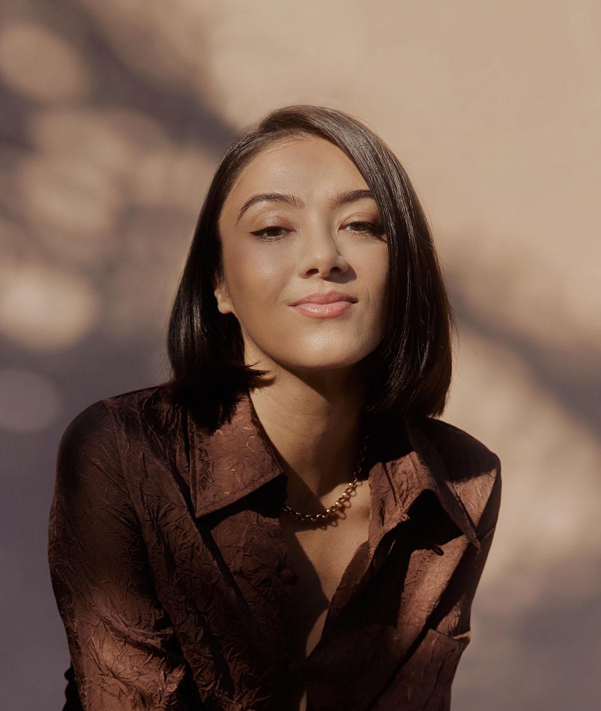 An artistic portrait photograph of a younger woman with dark hair