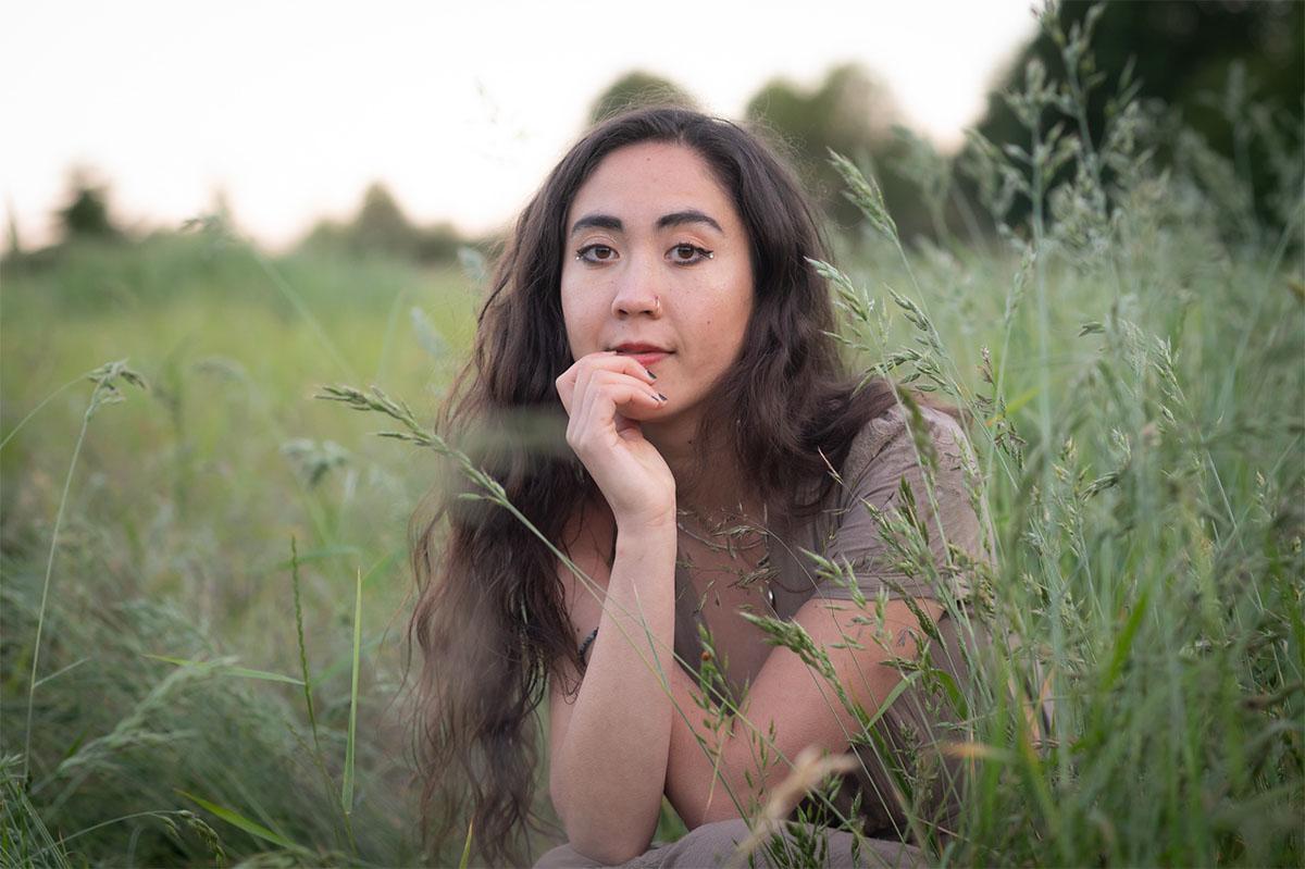 A younger woman in a field of tall grass