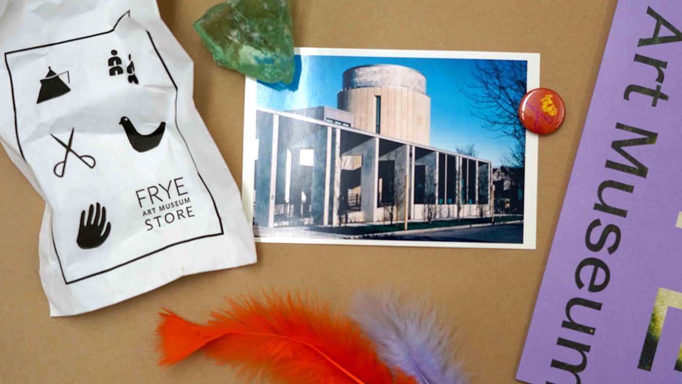 A variety of gathered materials, including a crumpled sheet of paper, rocks, a postcard, and more