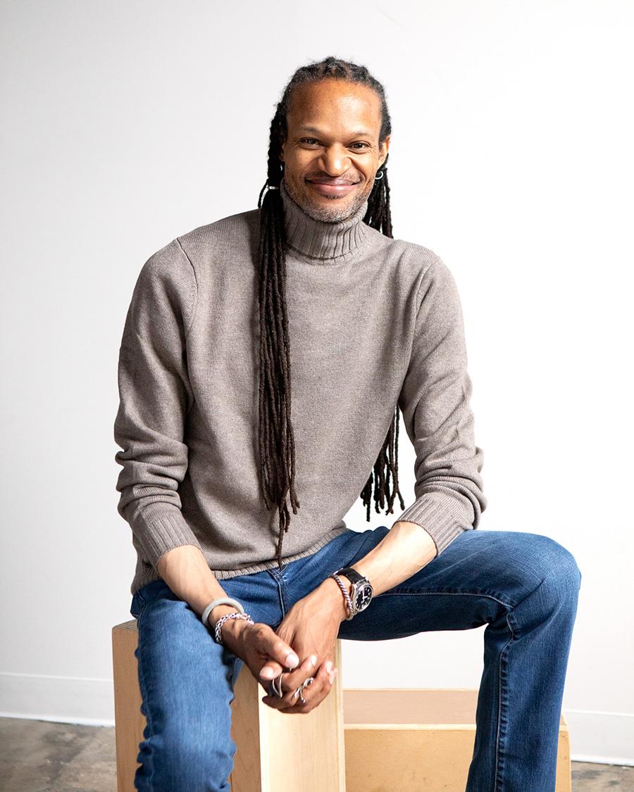 A smiling man sitting casually