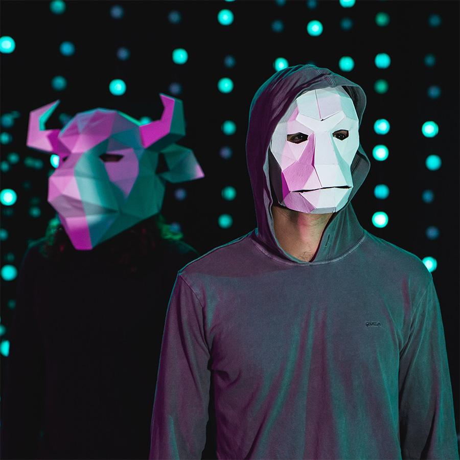 A masked person in a dark room illuminated by many small lights