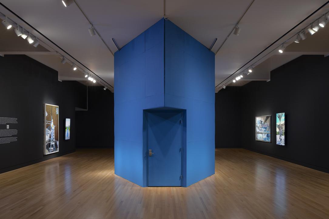 Photograph of "The Interim" recording booth, which is a large blue enclosed space, in the middle of a Frye gallery.