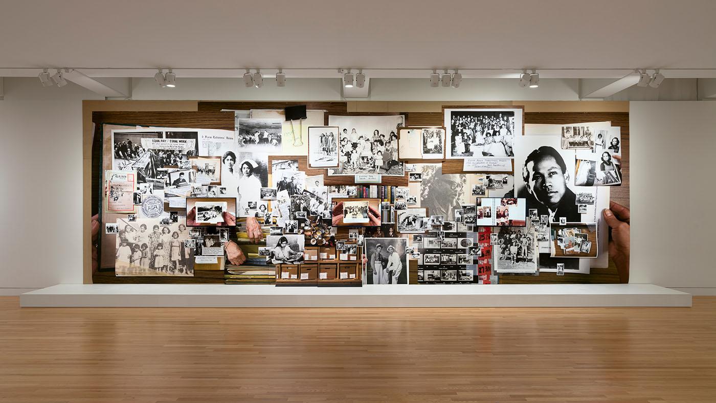 A large collage artwork covering a wall in a museum gallery