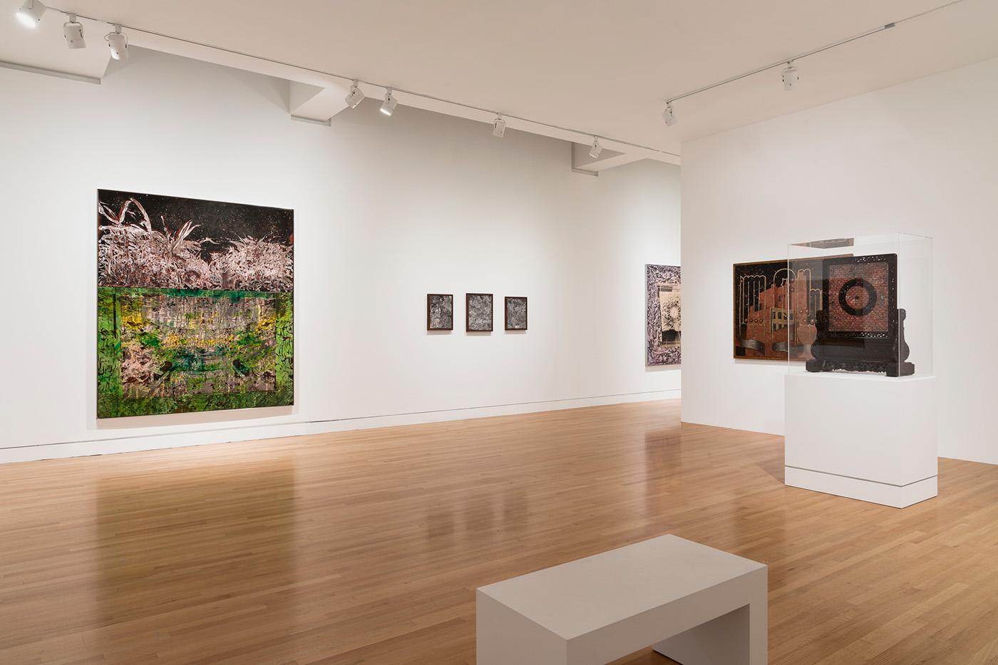 Artwork on walls and pedestals in a gallery