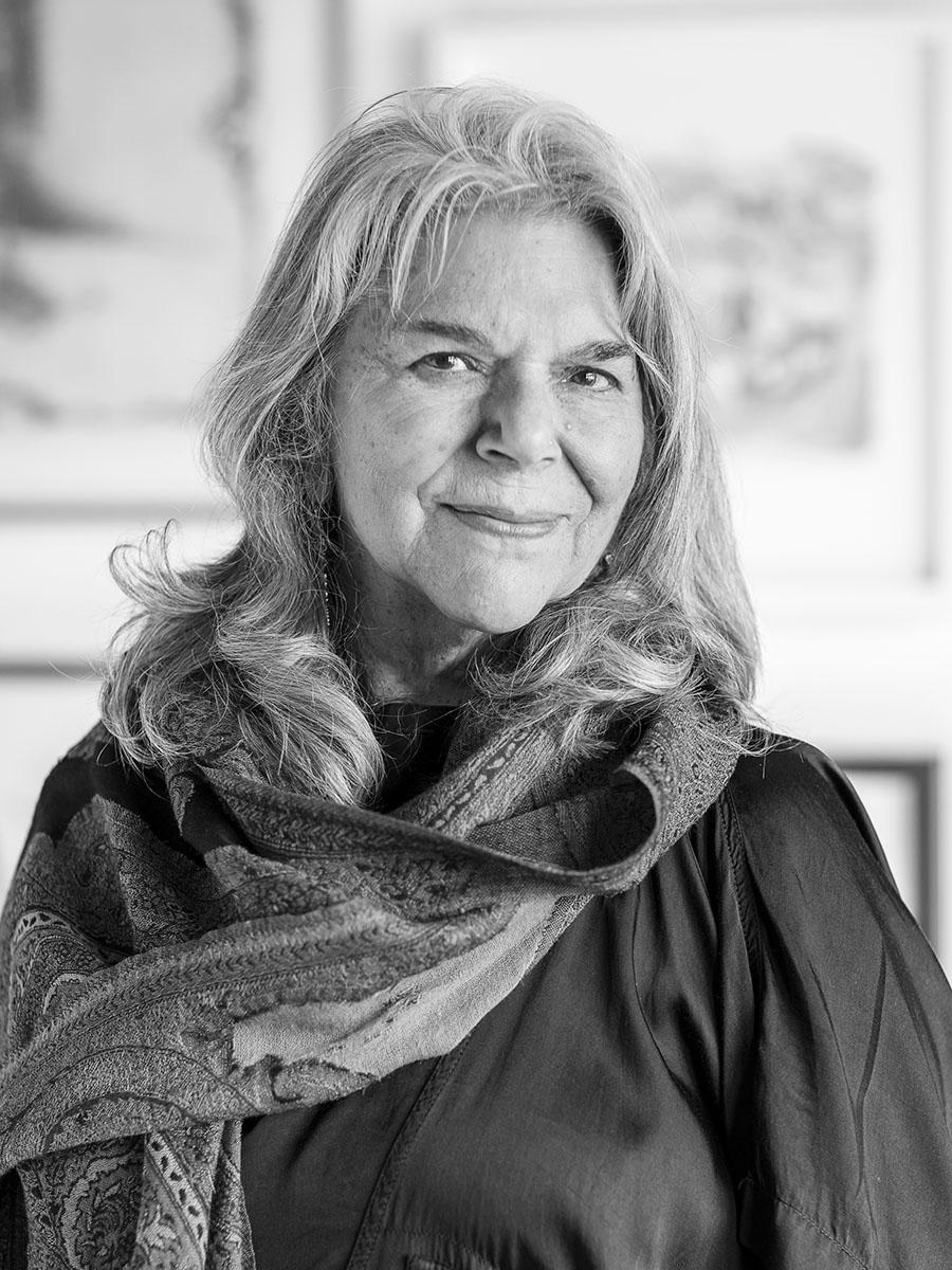 A black and white formal headshot style photograph of a woman wearing a shawl and dark top