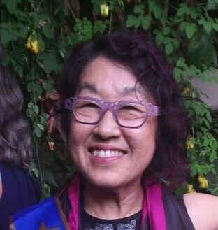 A photograph of a woman wearing purple glasses