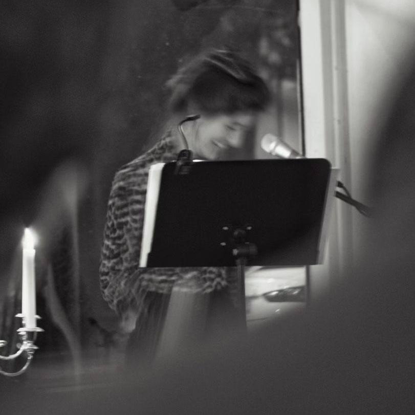 A black and white stylized photo of a woman behind a portable lectern